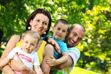 happy young couple with their children have fun at park