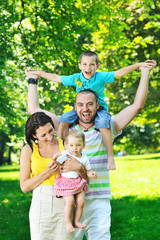 happy young couple with their children have fun at park