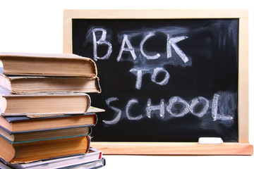 back to school written on chalkboard with books