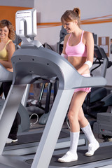 Fototapeta na wymiar Woman on running machine in gym