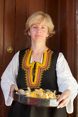 Woman in Bulgarian folk costume with mushrooms