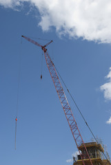 A Red Tower Crane under a blue sky