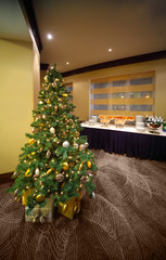 Christmas tree near table with cold snacks and champagne