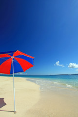 白い砂浜に立つカラフルなパラソル