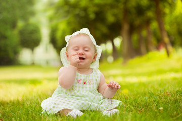 Summer portrait of beautiful baby on the lawn