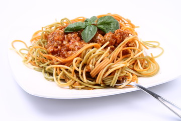 Spaghetti bolognese on a plate being eaten with a fork