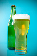 beer bottle and glass over a blue background.