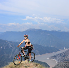 Young female posing seated on a mountain bike