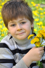 A boy with a bouquet of dandelions