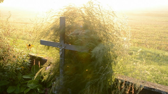 sunrise light and old crucifix on the field