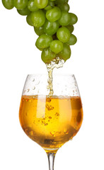 White wine pouring into glass.and grapes isolated on white