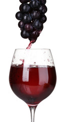 White wine pouring into glass.and grapes isolated on white