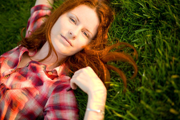 Happy woman relaxing on green grass.