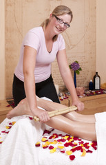 Bambusmassage - Wellnesmassage -  an einer hübschen, jungen Blo