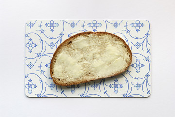 Slice of bread with butter on bread board