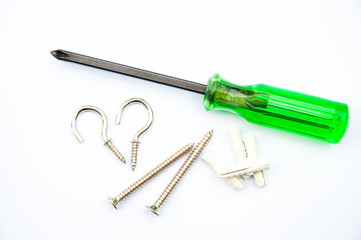 screwdriver and some screws and sleeve bolt on white floor
