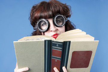 A cute woman wearing goggles with a book