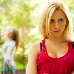 Naklejka premium Upset teenage girl being jeered by group of the other young peop