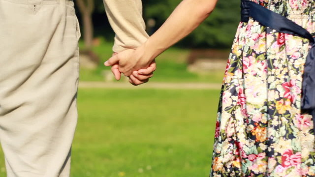 Young couple holding hands, outdoors