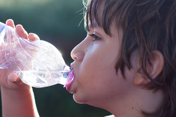 bambino beve acqua dalla bottiglia