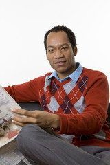 Smart casual male reading trade news in the paper