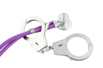 Stethoscope and handcuffs isolated on white background