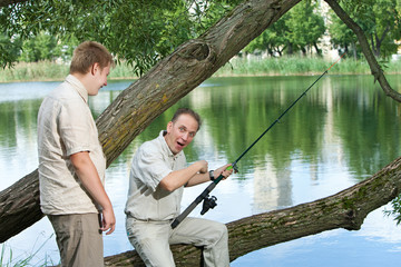 The father with the son on fishing.Rejoice to a biting