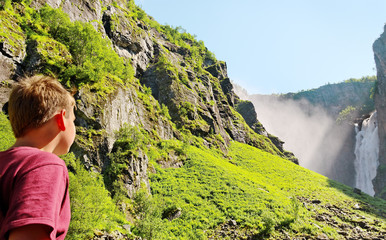 Naklejka premium Boy at the waterfall.