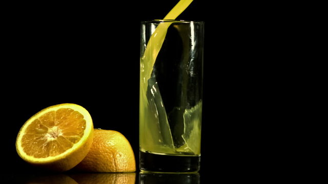 Orange juice pouring into glass in slow-motion