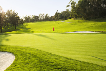 Flag on golf course surrounded by sand traps