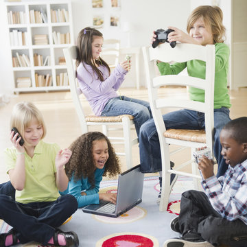 Children playing with various technology together