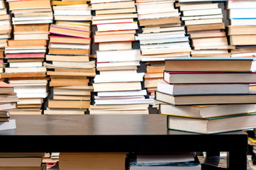 Books piled up against black desk