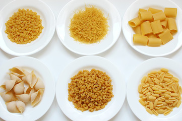 Six plates with dry pasta