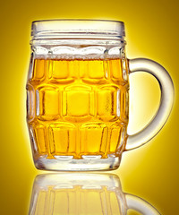Mug full of beer on a golden background
