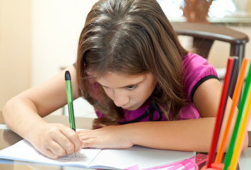 Small girl working on her school project at home