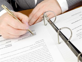 Female hand with pen signing a contract.