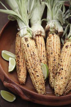 Roasted corn on the cob and limes in bowl
