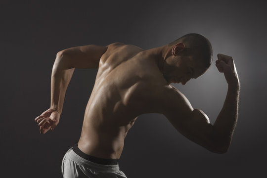 Mixed race athlete flexing biceps