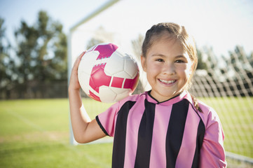 Hispanic girl soccer player holding soccer ball