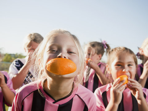 Girl soccer players eating orange slices