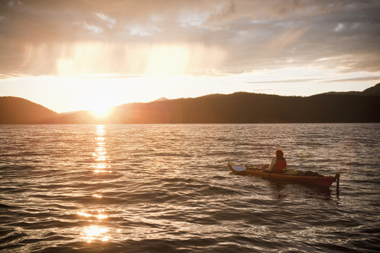 Hispanic woman kayaking on lake