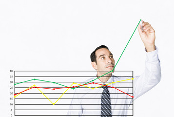 Hispanic businessman drawing chart on clear board