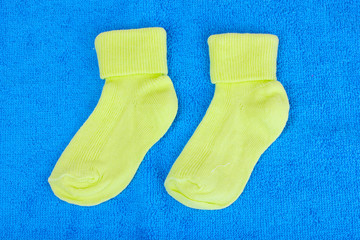 yellow baby socks on blue background