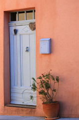 Naklejka premium Charmante alte Eingangstür dekoriert mit Herz und einem Oleander im Terracotta Topf in einem Dorf in der Provence, Côte d'Azur