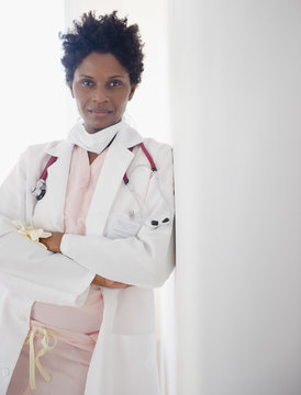 Black doctor leaning against wall