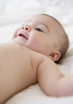 Mixed race baby laying on bed