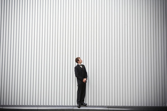 Uncertain groom standing near wall