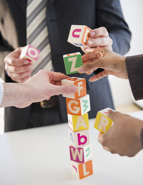 Business people stacking alphabet blocks