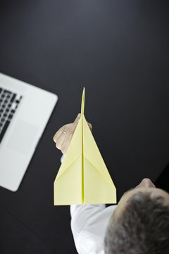 Caucasian businessman flying paper airplane