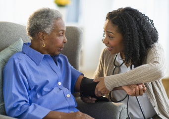 Nurse taking woman’s blood pressure